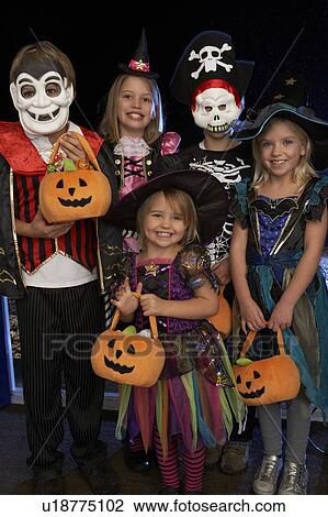 Stock Image - Happy Halloween party with children trick or treating. Fotosearch