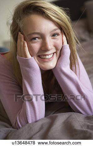 Stock Photo - Happy Teenage Girl Sitting In Bedroom. Fotosearch