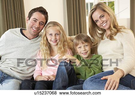 Happy young family sitting on sofa View Large Photo Image Stock Photo - Happy young family sitting on sofa. Fotosearch