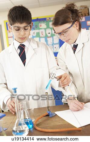 Picture - Male And Female Teenage Student In Science Class With Experiment. Fotosearch