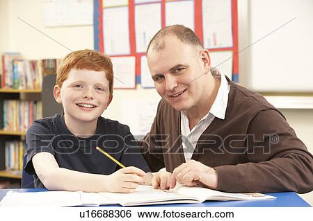 Male Pupil Studying in classroom with teacher View Large Photo Image Stock Photograph - Male Pupil Studying in classroom with teacher. Fotosearch