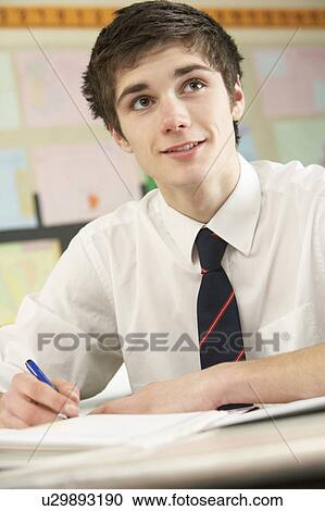 Stock Image - Male Teenage Student Studying In Classroom. Fotosearch