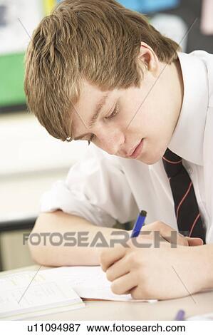 Stock Photo - Male Teenage Student Studying In Classroom. Fotosearch