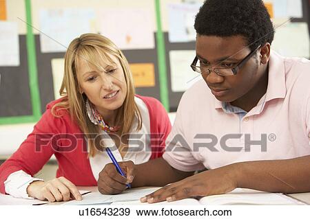 Male Teenage Student Studying In Classroom With Teacher View Large Photo Image Stock Photo - Male Teenage Student Studying In Classroom With Teacher. Fotosearch