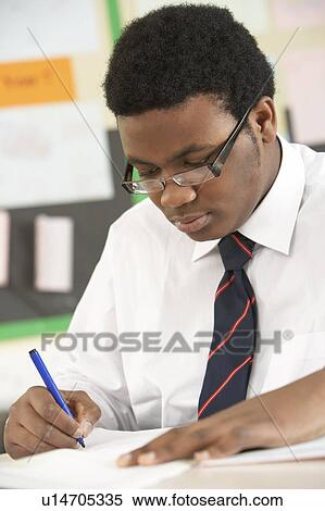 Stock Photography - Male Teenage Student Studying In Classroom. Fotosearch