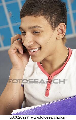 Male Teenage Student Using Mobile Phone By Lockers In School View Large Photo Image Stock Photo - Male Teenage Student Using Mobile Phone By Lockers In School. Fotosearch