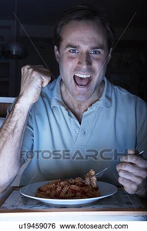 Man Enjoying Meal And Cheering Whilst Watching TV View Large Photo Image Stock Photograph - Man Enjoying Meal And Cheering Whilst Watching TV. Fotosearch