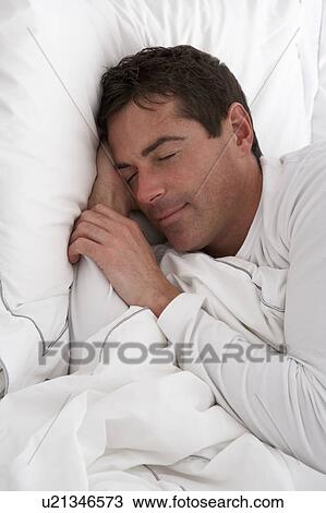 Stock Image - Man Sleeping Peacefully In Bed. Fotosearch