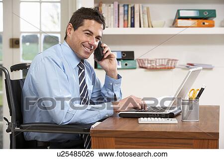 Stock Photograph - Man Working From Home Using Laptop On Phone. Fotosearch
