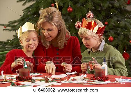 Stock Image - Mother And Children Making Christmas Cards Together. Fotosearch