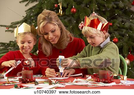 Stock Photo - Mother And Children Making Christmas Cards Together. Fotosearch
