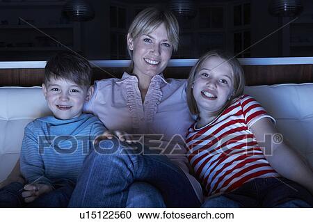 Mother And Children Watching Programme On TV Sitting On Sofa Together View Large Photo Image Stock Image - Mother And Children Watching Programme On TV Sitting On Sofa Together. Fotosearch