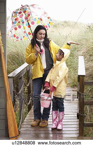 Stock Photo - Mother and daughter with umbrella. Fotosearch