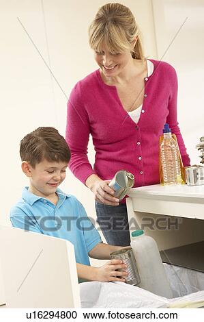 Stock Image - Mother And Son Recyling Waste At Home. Fotosearch