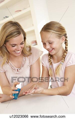 Mother putting sanitizer on young girl's hands View Large Photo Image Stock Photograph - Mother putting sanitizer on young girl's hands. Fotosearch