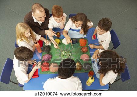 Picture - Overhead View Of Schoolchildren Working Together At Desk. Fotosearch