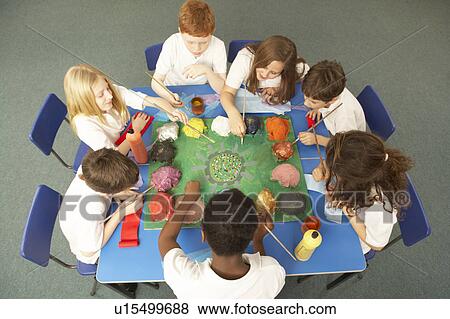 Stock Photo - Overhead View Of Schoolchildren Working Together At Desk. Fotosearch