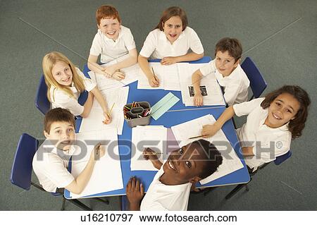 Stock Photo - Overhead View Of Schoolchildren Working Together At Desk. Fotosearch