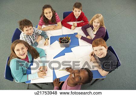 Stock Photo - Overhead View Of Schoolchildren Working Together At Desk. Fotosearch