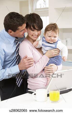 Stock Photography - Parents With Baby Working From Home Using Laptop. Fotosearch