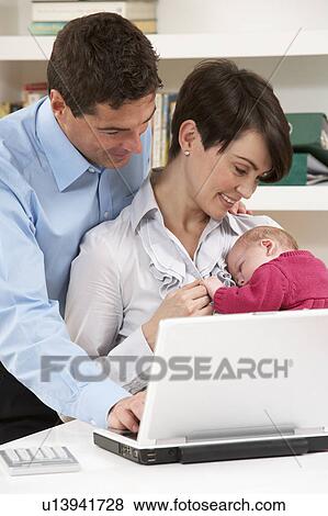 Stock Photo - Parents With Newborn Baby Working From Home Using Laptop. Fotosearch