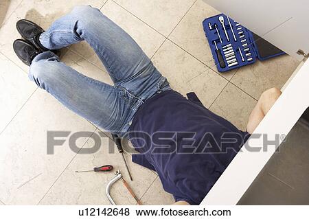 Plumber Working On Sink In Kitchen View Large Photo Image Stock Photo - Plumber Working On Sink In Kitchen. Fotosearch