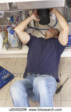 Plumber Working On Sink In Kitchen View Large Photo Image Stock Photograph - Plumber Working On Sink In Kitchen. Fotosearch