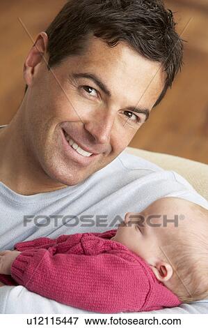 Stock Photo - Portrait Of Father With Newborn Baby At Home. Fotosearch