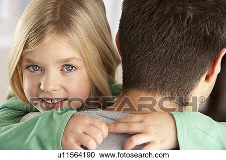 Stock Image - Portrait Of Happy Daughter Looking Over Fathers Shoulder. Fotosearch