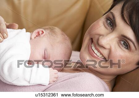 Stock Image - Portrait Of Mother With Newborn Baby At Home. Fotosearch