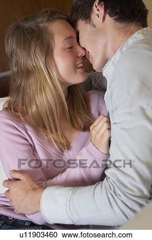 Romantic Teenage Couple Kissing On Sofa At Home Together View Large Photo Image Stock Image - Romantic Teenage Couple Kissing On Sofa At Home Together. Fotosearch