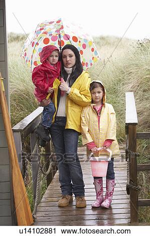 Stock Image - Sad mother and children on beach. Fotosearch