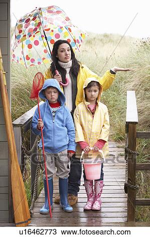 Stock Image - Sad mother and children on beach. Fotosearch