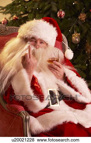 Stock Photo - Santa Claus Making Rude Gesture To Camera In Front Of Christmas Tree. Fotosearch
