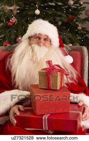 Santa Claus Sitting In Armchair In Front Of Christmas Tree View Large Photo Image Stock Photo - Santa Claus Sitting In Armchair In Front Of Christmas Tree. Fotosearch