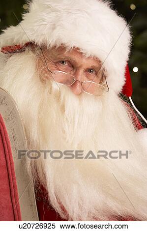 Santa Claus Sitting In Armchair In Front Of Christmas Tree View Large Photo Image Stock Photography - Santa Claus Sitting In Armchair In Front Of Christmas Tree. Fotosearch
