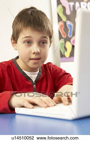 Stock Image - Schoolboy In IT Class Using Computer. Fotosearch