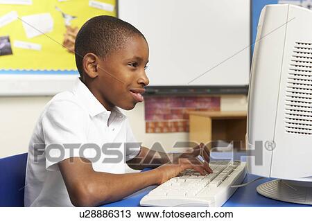 Stock Image - Schoolboy In IT Class Using Computer. Fotosearch