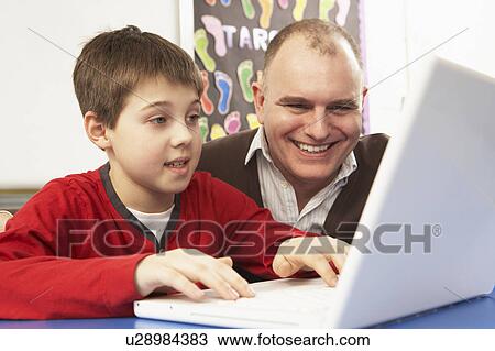 Schoolboy In IT Class Using Computer With Teacher View Large Photo Image Stock Image - Schoolboy In IT Class Using Computer With Teacher. Fotosearch