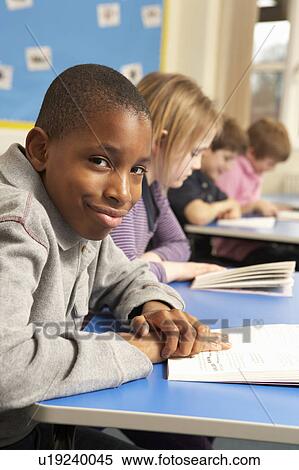 Schoolboy Reading Book In Classroom View Large Photo Image Stock Photography - Schoolboy Reading Book In Classroom. Fotosearch