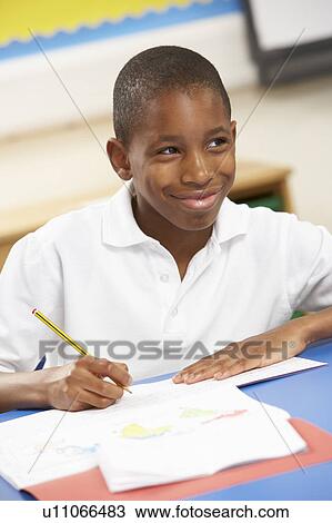 Stock Image - Schoolboy Studying In Classroom. Fotosearch