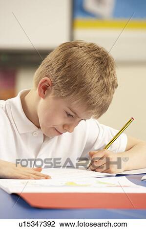 Stock Image - Schoolboy Studying In Classroom. Fotosearch