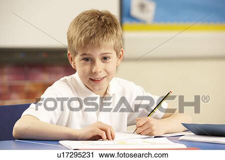 Stock Image - Schoolboy Studying In Classroom. Fotosearch