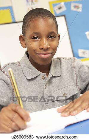 Stock Image - Schoolboy Studying In Classroom. Fotosearch
