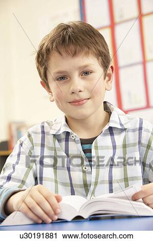 Schoolboy Studying Textbook In Classroom View Large Photo Image Stock Image - Schoolboy Studying Textbook In Classroom. Fotosearch