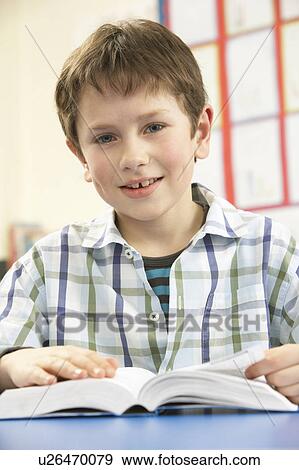 Schoolboy Studying Textbook In Classroom View Large Photo Image Stock Photo - Schoolboy Studying Textbook In Classroom. Fotosearch