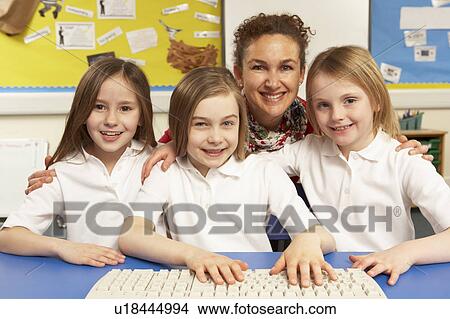 Picture - Schoolchildren in IT Class Using Computers With Female Teacher. Fotosearch