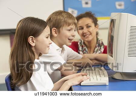 Schoolchildren In IT Class Using Computer with teacher View Large Photo Image Stock Image - Schoolchildren In IT Class Using Computer with teacher. Fotosearch