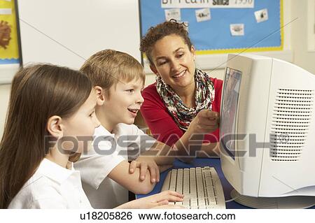 Schoolchildren In IT Class Using Computer with teacher View Large Photo Image Stock Photograph - Schoolchildren In IT Class Using Computer with teacher. Fotosearch