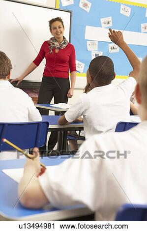 Stock Image - Schoolchildren Studying In Classroom With Teacher. Fotosearch